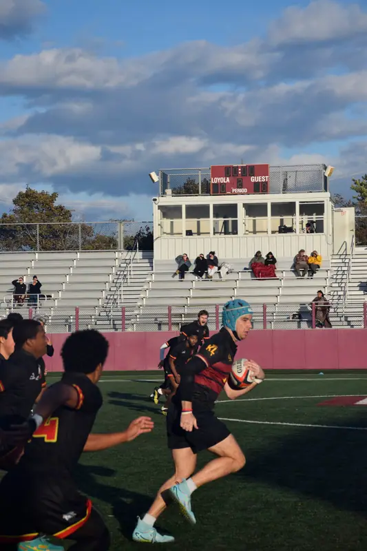 Loyola player carrying the ball near the sideline